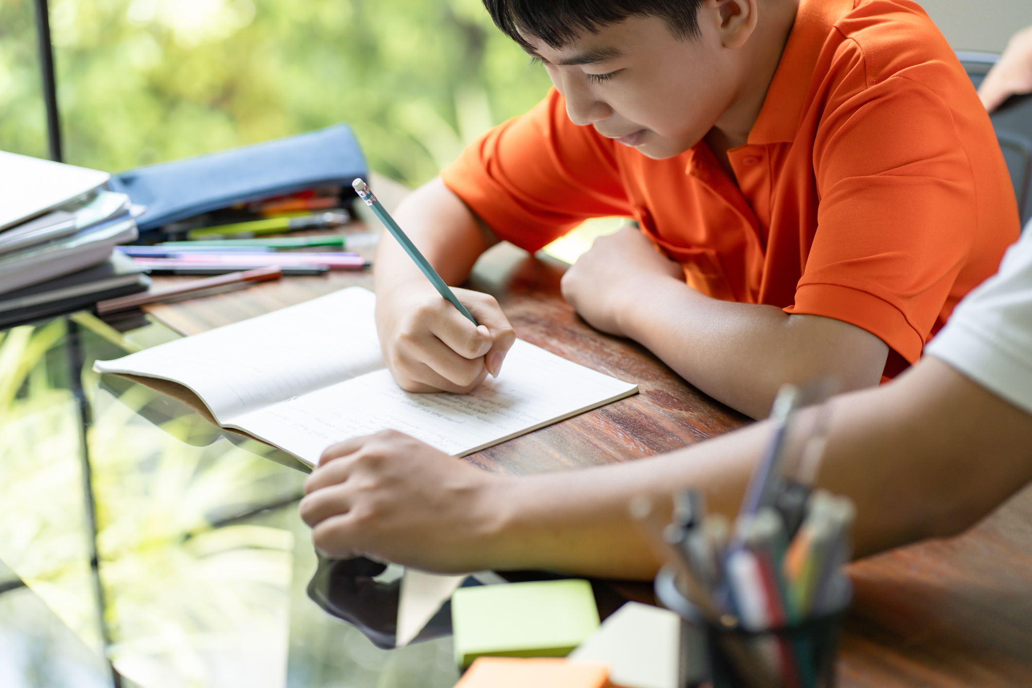 Asian father helps son to do her homework for the school.child study together homeschooling concept getting homework help from father