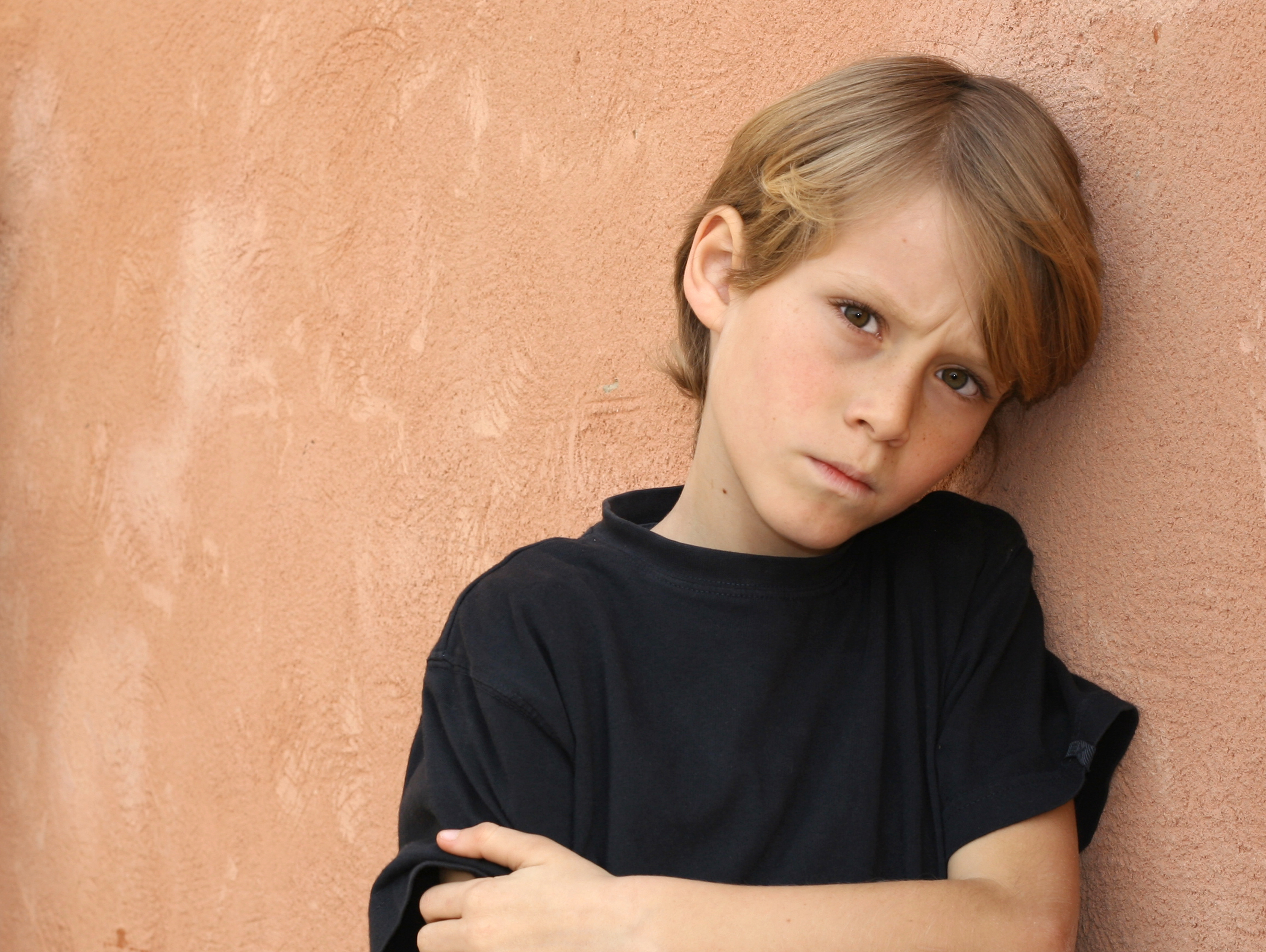 annoyed-boy-against-wall-shutterstock