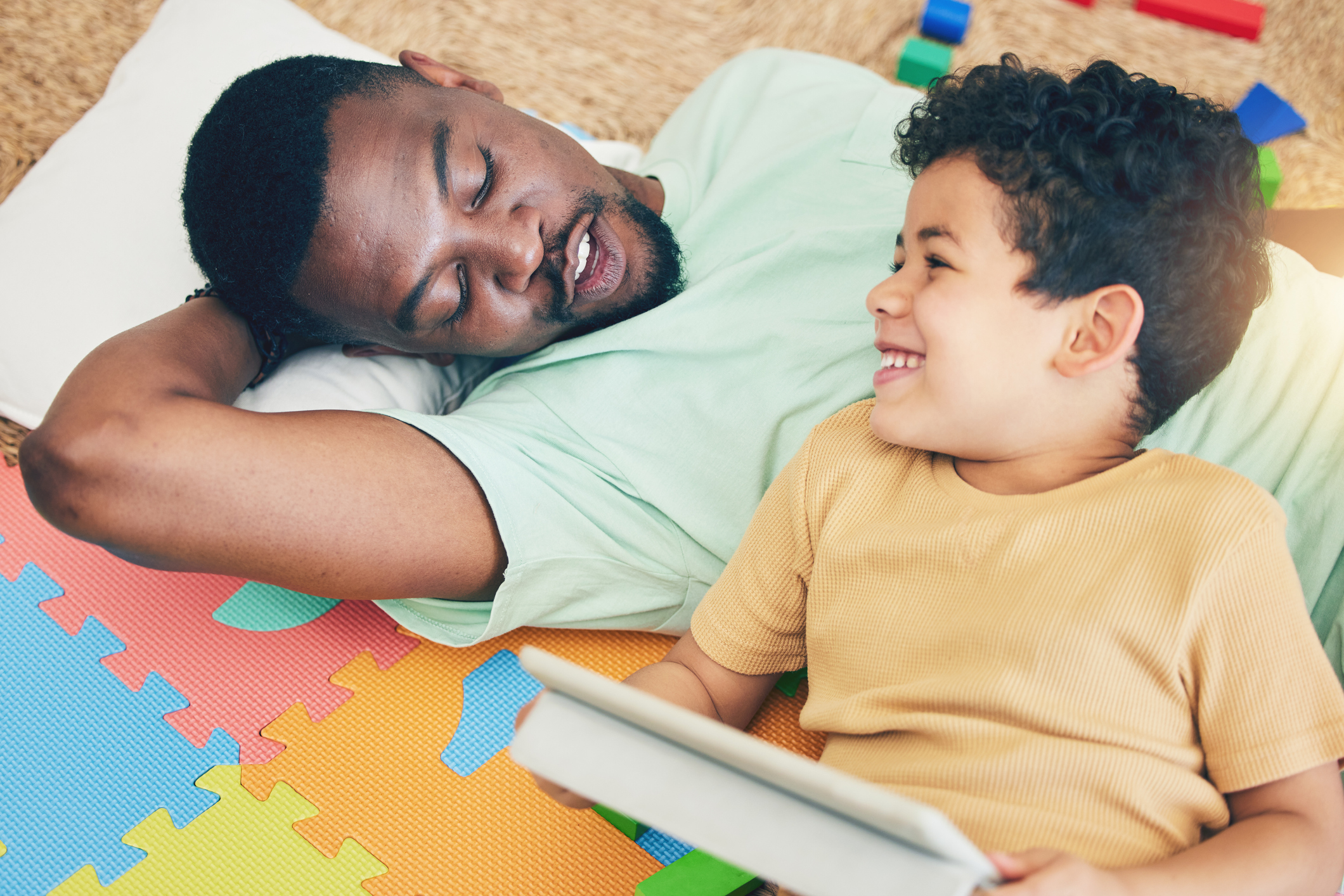 Relax, father and boy on floor with tablet for playing, creative activity and fun learning with digital tech. Education, child development and dad and kid enjoy online game, internet and bond at home