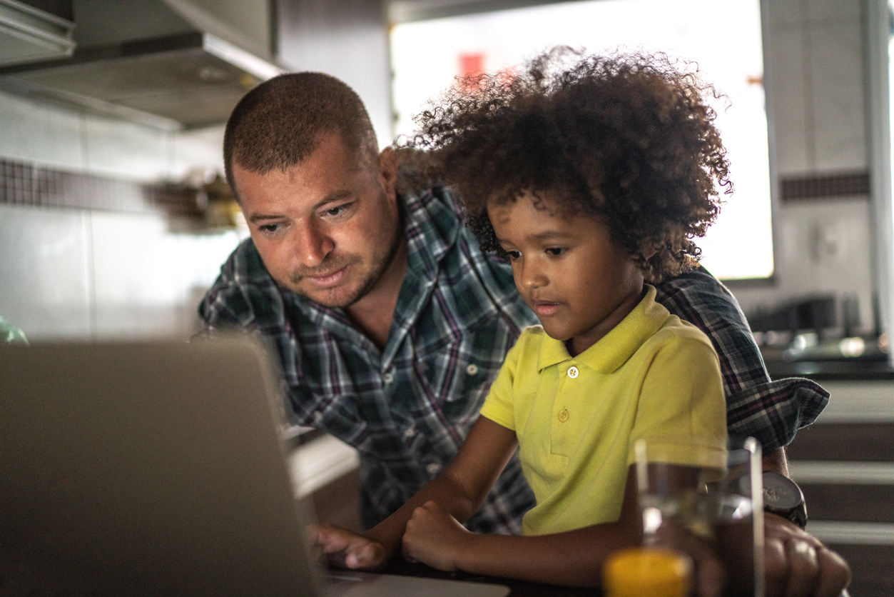 Father and son using laptop at home